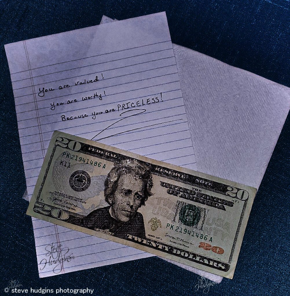 A note and a $ 1 0 bill on top of a desk.